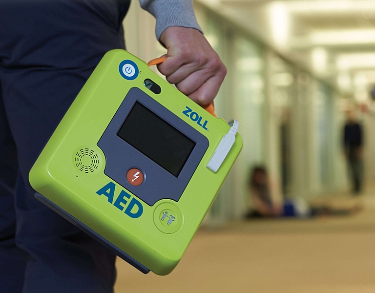 Файл:ZOLL-AED-3-image-with-person-carrying-scaled.jpg